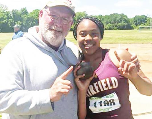 Breyunna Dowell wins first place in the discus competition to move on to State. She is pictured with Coach Kevin Childers. Contributed photo
