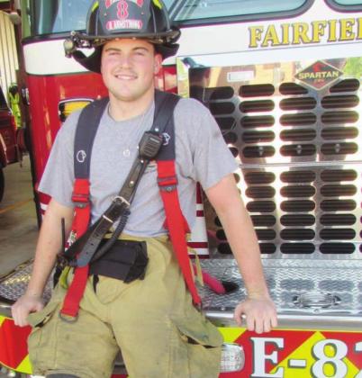 Riley Armstrong, a graduating Fairfield High School senior and Fairfield Volunteer Fire Department member, clads part of the work suit and wears the protective heavy helmet required for his job. Photo by Curtis Burton/Fairfield-Recorder