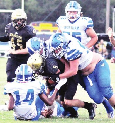 A trio of Wortham tacklers team up to bring down Dawson’s Cade Onstott (5) during a game in Dawson on Friday night. Making the play for the Bulldogs are Mason Montgomery (54), Yancey Bean (7) and Derek Bullard (14). Photos contributed by Melissa Perez
