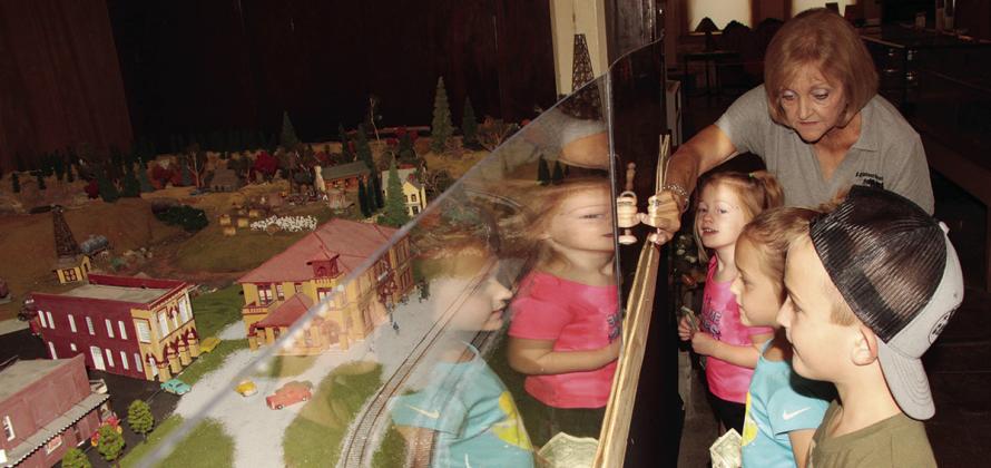ABOVE: Mary Lee, treasurer of the B&amp;RI (Burlington &amp; Rock Island) Railroad Museum, shows the miniature railroad to young attendees at the Railroad Museum, from front, Cale Hurst, 6, and his sisters, Camryn, 5, and Caisley, 4, all of Teague. BELOW LEFT: Liam Newman was declared Engineer of the Day at the Teague Public Library on Saturday, Oct. 21, part of the children’s events of the Tri-County Railroad Symposium. Photos by Roxanne Thompson/Fairfield Recorder