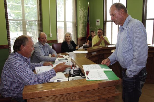 Jack Hays, right, a managing partner with Cotton Gin Ranch Land Company, shows Freestone County Commissioners Court surveys of a 75-acre tract of land the company bought in Freestone County and plans to develop into 18-acre tracts. Shown clockwise from left are Commissioners Clyde Ridge Jr. and Lloyd Lane, County Judge Linda Grant and Commissioner Will McSwane. Present but not shown is Commissioner Andy Bonner. At rear is County Clerk René Reynolds. Photo by Roxanne Thompson/Fairfield Recorder