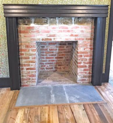 The living room fireplace is a close reproduction in size and style, utilizing some reclaimed brick and stone from the original house. Photo by Mary Cryer Awalt