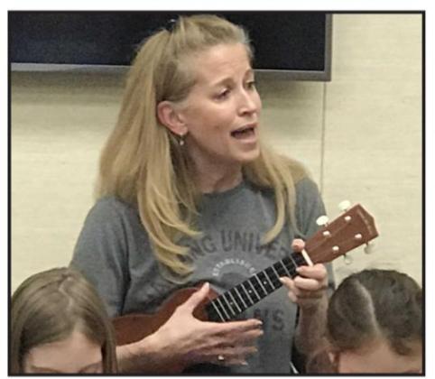 TSAC leader Rachel Bossier takes to the ukulele with her students. Photo by Mary Cryer Awalt