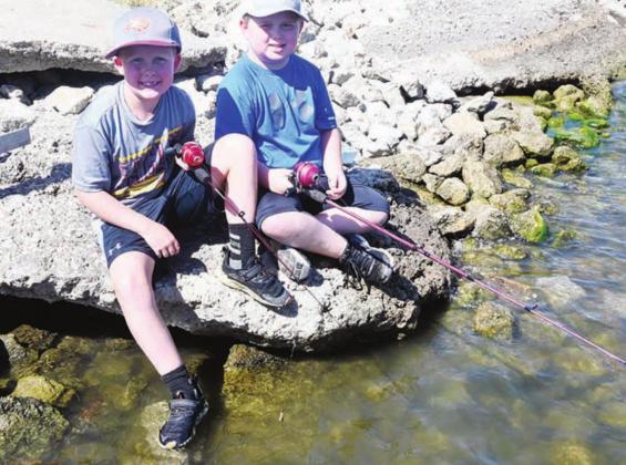 LEFT: Friends Toley Meister and Mason Bailon of Fairfield enjoy fishing together at Fairfield Lake on Saturday morning, July 9, during the 20th Annual Kid Fish Derby hosted by KNES 99.1.