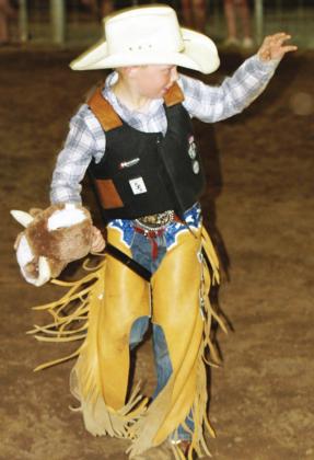 Holding on as his bull spun like a whirling dervish, stick bull riding competitor Corbin DeFrance rode all the way to the top spot at Monday night’s competition at the fairgrounds. Photo by Mary Cryer Awalt/Fairfield Recorder