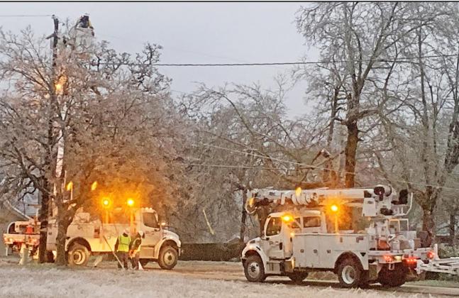 Linemen have been working the past week on restoring electricity throughout the county due to the freezing temperatures and ice. Multiple trees fell on power lines and power lines fell due to the weight of the ice. Photo by Mitchell Pate