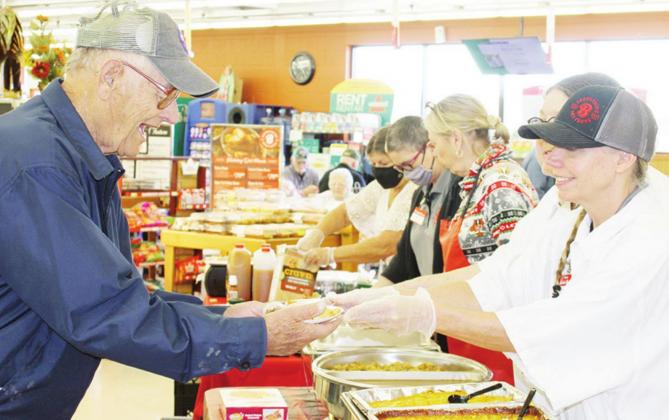 Barney Leach of Fairfield, left, samples holiday goodies served by Bakery/Deli Clerk Terri Borter at the Brookshire Brothers Taste of the Holidays event last Saturday. Photo by Mary Cryer Awalt