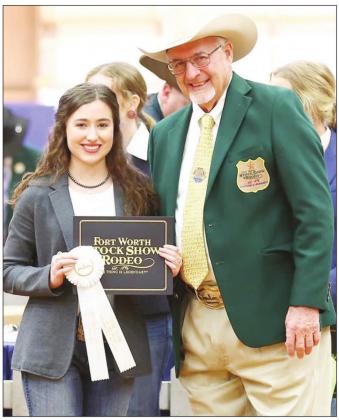 Ally Robinson receives her $10,000 scholarship from Breeding Beef Heifer Show Superintendent Dr. Tom Woodward of Decatur, Texas at the Ft. Worth Stock Show.