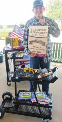 Power Burck of the Freestone County 4-H shows off his Champion Junior Showmanship banner for his Ag Mechanics project, a welding cart.