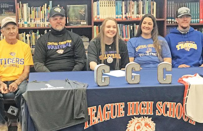 Teague High School senior Laykin Harkcom, center, signs her letter of intent to play volleyball with Central Christian College of Kansas. She is flanked by her family, including from left, her grandfather Larry Jander and her father Marty Harkcom; and on her other side, mother Dori Harkcom and brother Slade Harkcom. Photo by Mary Cryer Awalt