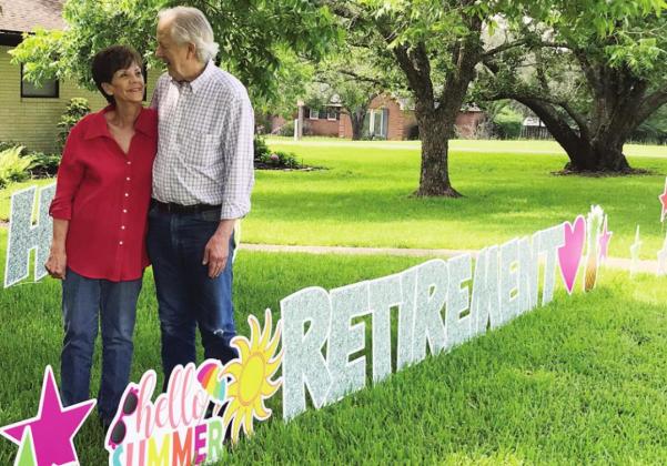 Carolyn and Danny Robertson of Fairfield pose in their front yard with a “Retirement” sign the day after selling Rob’s Drive In. Photo by Mary Cryer Awalt/ Fairfield Recorder