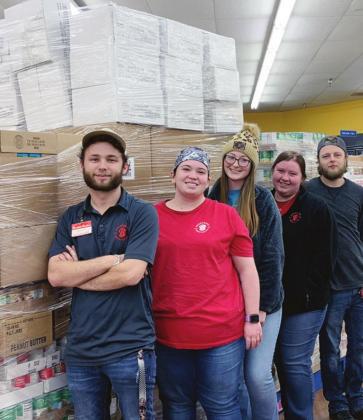 on ABOVE: Justin Hazelwood, Lauren Doggett, Skyler Williams, and Shayne Downey with the eight pallets of food donated through the “Brown Bags of Hope” program to the local community food bank. e